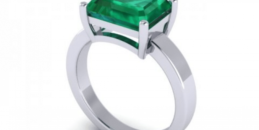 An emerald stone engagement ring in white gold.