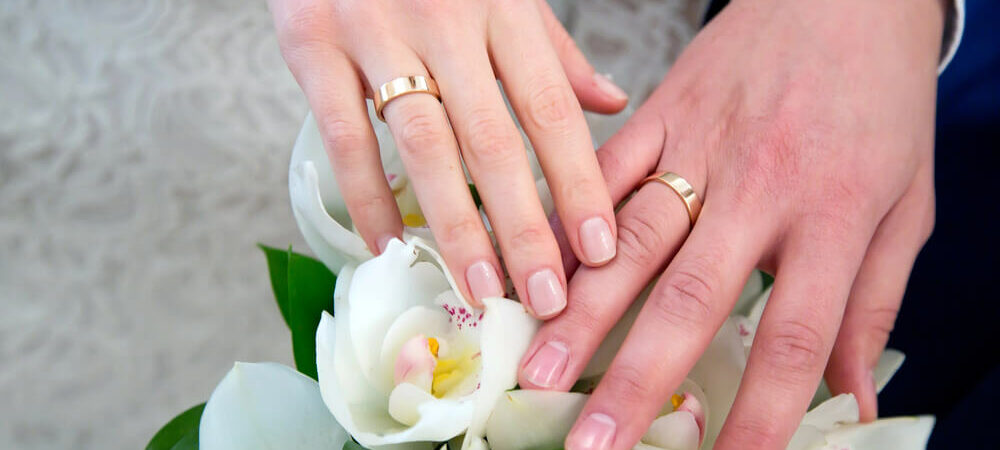 newlyweds hands with a wedding band