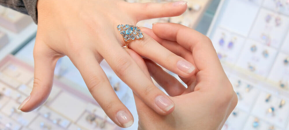 A girl trying a diamond ring on her finger